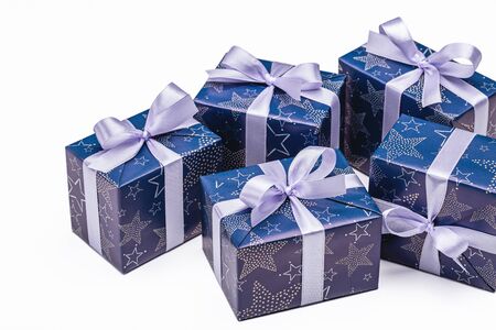 Lot of gift boxes on white background. Craft gifts and blue paper decorated with lilac satin ribbon...