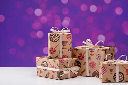 A set of gifts in cheerful package, decorated with ribbons with bows. Against the background of...