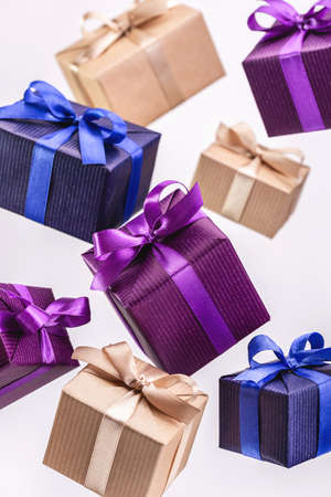 Gift. Flying boxes in colored paper tied with ribbon on white background, isolated.