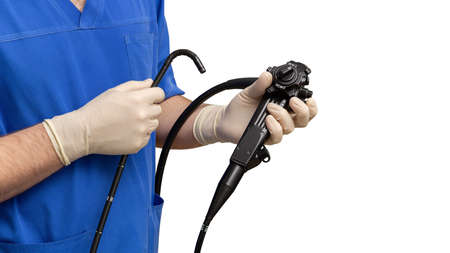 Male doctor gastroenterologist holding an endoscope with his hands in protective gloves.