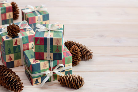 Merry Christmas and Happy New Year. Pine cones and gifts in elegant paper with winter pattern, on...