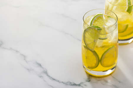 Two glasses of refreshing lemonade with lime and lemon. Copy space, marble background.の写真素材