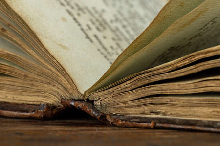 An open antique book on an old wooden table. Studio shot, copy space.の写真素材
