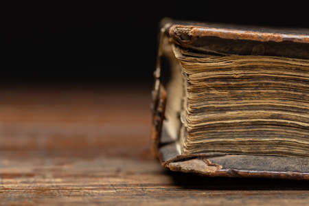 Part of an antique book is visible on an old wooden table, close-up.の写真素材