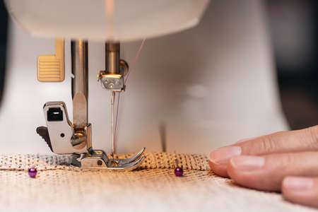 Women's hands behind her sewing. Sewing process. Studio shot with lighting equipment.