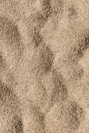 Wallpaper, texture of a beach of sea sand in the form of dunes. Summer, vacation and sea concept.の写真素材