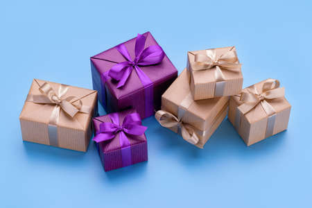 Gift boxes in elegant packaging with ribbons and bows. Blue background, copy space.の写真素材