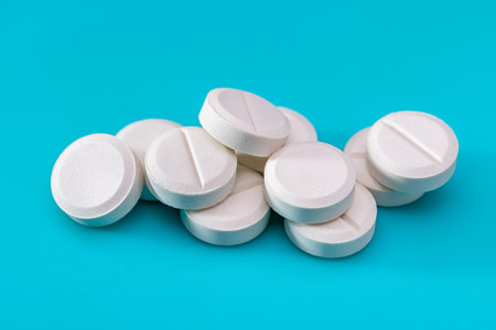 Sample of white medical pills on a blue background. Top view, copy space.の写真素材