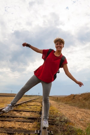 smiling teen girl walking on old rail roadの写真素材
