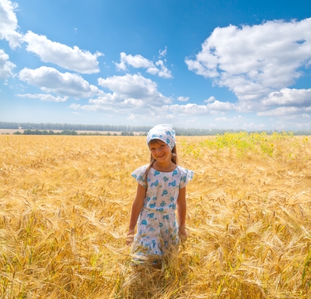 beautiful happy little girl in a meadow summer timeの写真素材