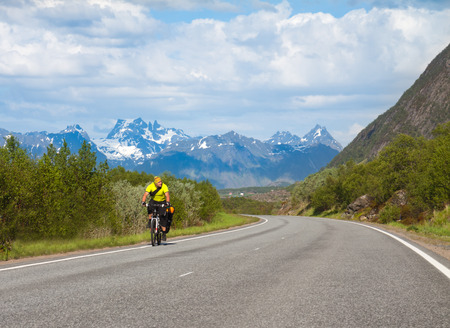 Mountain bike cyclist at sphalt road, Lofoten, Norwayの写真素材