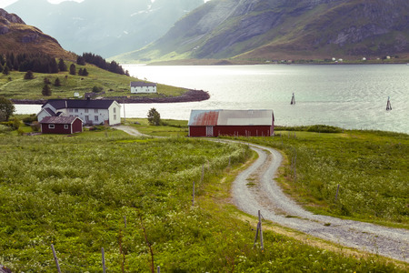 view of fjord, snow mountains and traditional village in Norway
