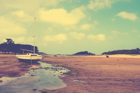 old boat in low tide  on beach of Brittany, old styleの写真素材