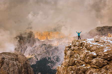 man on the top of a rock  meeting sunの写真素材