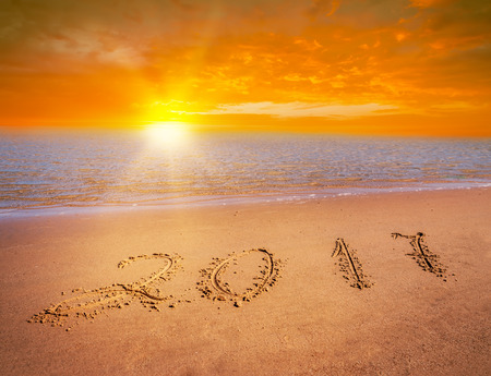 new year 2017 digits on ocean beach sand