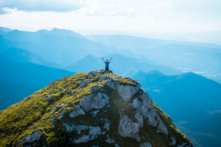 man on the top of a rock meeting sunの写真素材