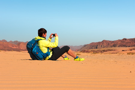 Woman mountain Hiker with backpack makes photo in Sinai desertの写真素材