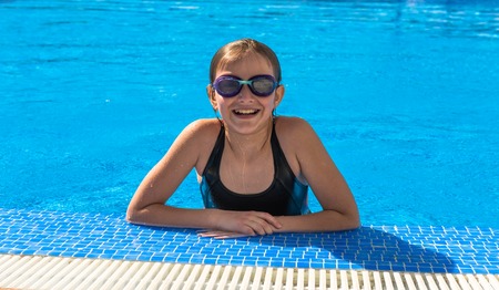 Cute teen girl in swimming pool Happy girl enjoys summer water and holidays in holiday destinationsの写真素材