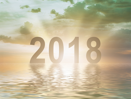 Happy new year 2018 digits text on sunset blur background reflecting in waterの写真素材