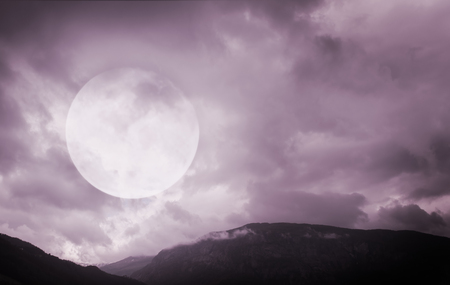 Halloween background. Spooky dark mountains with full moonの写真素材