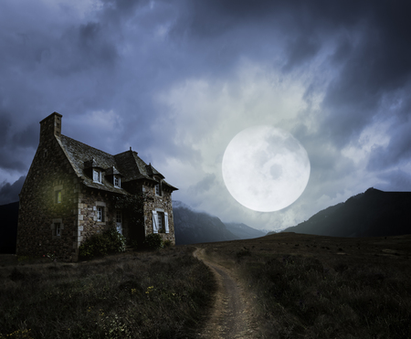 Apocalyptic Halloween scenery with old house and moonの写真素材