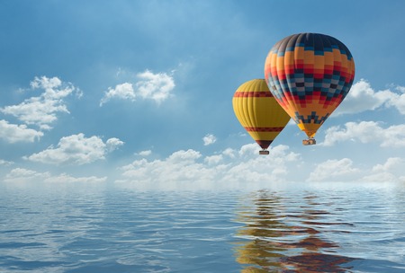 Colorful hot air balloon fly over the blue sea.の写真素材