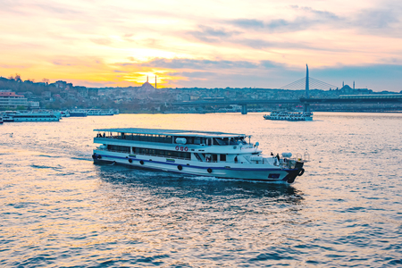 Tourist boat in Golden Horn, Istanbul at sunset, Turkeyの写真素材