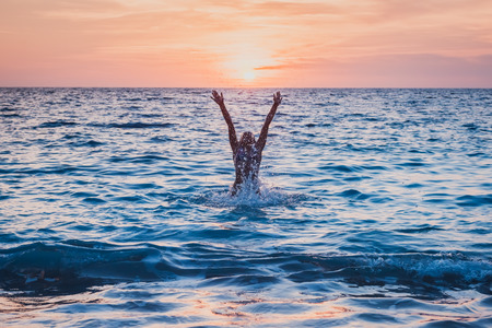Happy child playing in the sea. Kid having fun outdoors. Summer vacation and healthy lifestyle concept. Toned imageの写真素材