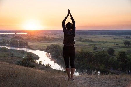 Meditation in sunrise summer field. Relax health conceptの写真素材