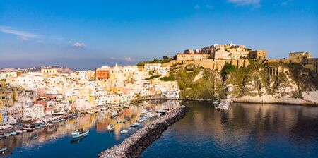 Aerial drone view of vibrantly colorful houses of Marina Corricella in sunny summer weather at Procida island, Italyの写真素材