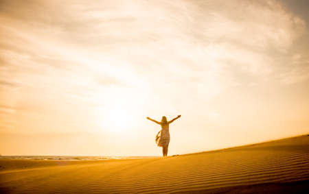 Freedom and happiness. Along young woman on sand enjoying sun, nature.の写真素材