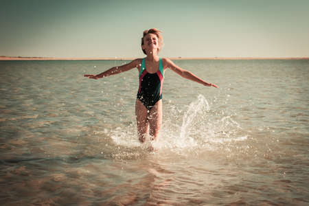 Little girl playing on beautiful ocean beachの写真素材