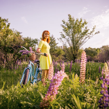 Young teen girl with vintage bike in flowered meadowの写真素材