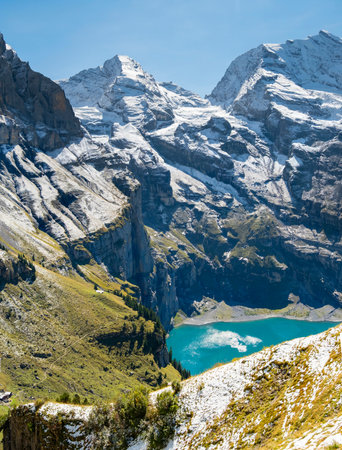 Idyllic morning view of the lake Oeschinensee. Location Swiss alps, Switzerland, Kandersteg district. Blue mountain lake with pine trees and mountains in background.の写真素材