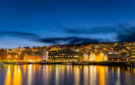 Panorama of the Norwegian city of Tromso on a winter evening during the Christmas season. The boat...