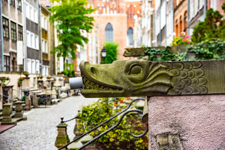 Captivating view of intricate wrought iron railings set against the historic red brick buildings in Gdansk Old Town. The architectural detail reflects the city's rich historyの写真素材