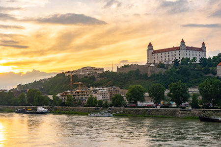 Scenic view of Bratislava Castle at sunset, overlooking the Danube River. Captures the iconic castle in Slovakia with a dramatic sky, blending historical architecture with natural beauty.の写真素材