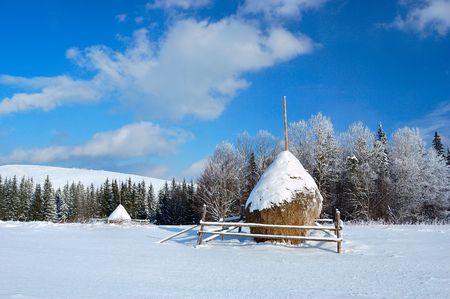 Haystacks in the mountains of bright frosty winter day.の写真素材