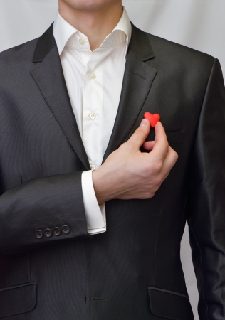 A man in a suit with a red heart in her handの写真素材
