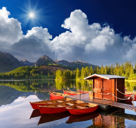 Beautiful red boat in a mountain lake Strbske Pleso, Slovakia, Europeの写真素材