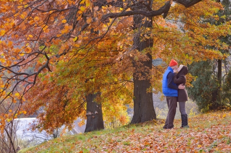 Couple kissing in autumn park on a sunny dayの写真素材