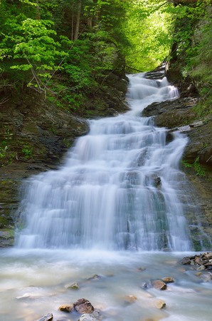 Spring landscape with a waterfall on a mountain riverの写真素材