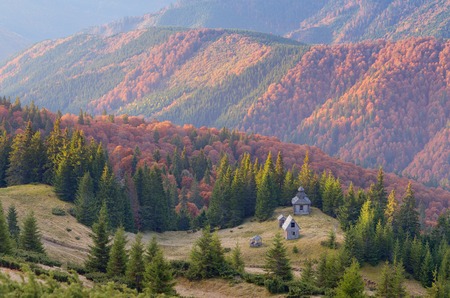 Autumn landscape with old wooden church in the mountainsの写真素材