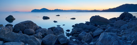 Landscape panorama at sunset  Sea shore with stones  A warm summer eveningの写真素材