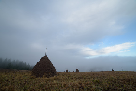 Autumn landscape. Haystack in the mist. Agriculture in the mountainsの写真素材