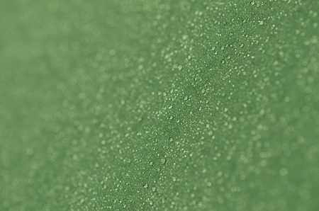 Drops of morning dew on a tourist tent. Abstract background of green fabric. Shallow depth of field