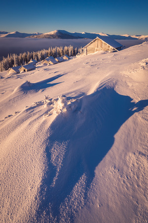 Winter in the mountain village. Landscape with snow driftsの写真素材