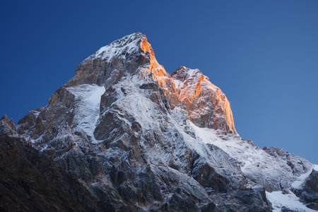 Mountain top at sunrise. Mount Ushba, Svaneti, Georgia, Caucasus. The first rays of the sun. Beauty in natureの写真素材