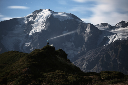 Night landscape. Alone hiker standing on a hill. Moonlight and flashlight. Mountain Mkheer. Caucasus, Georgia, Zemo Svanetiの写真素材