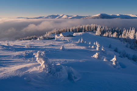 Winter landscape. Sunny morning with blue sky. Wooden houses in the mountains. Carpathians, Ukraine, Europeの写真素材